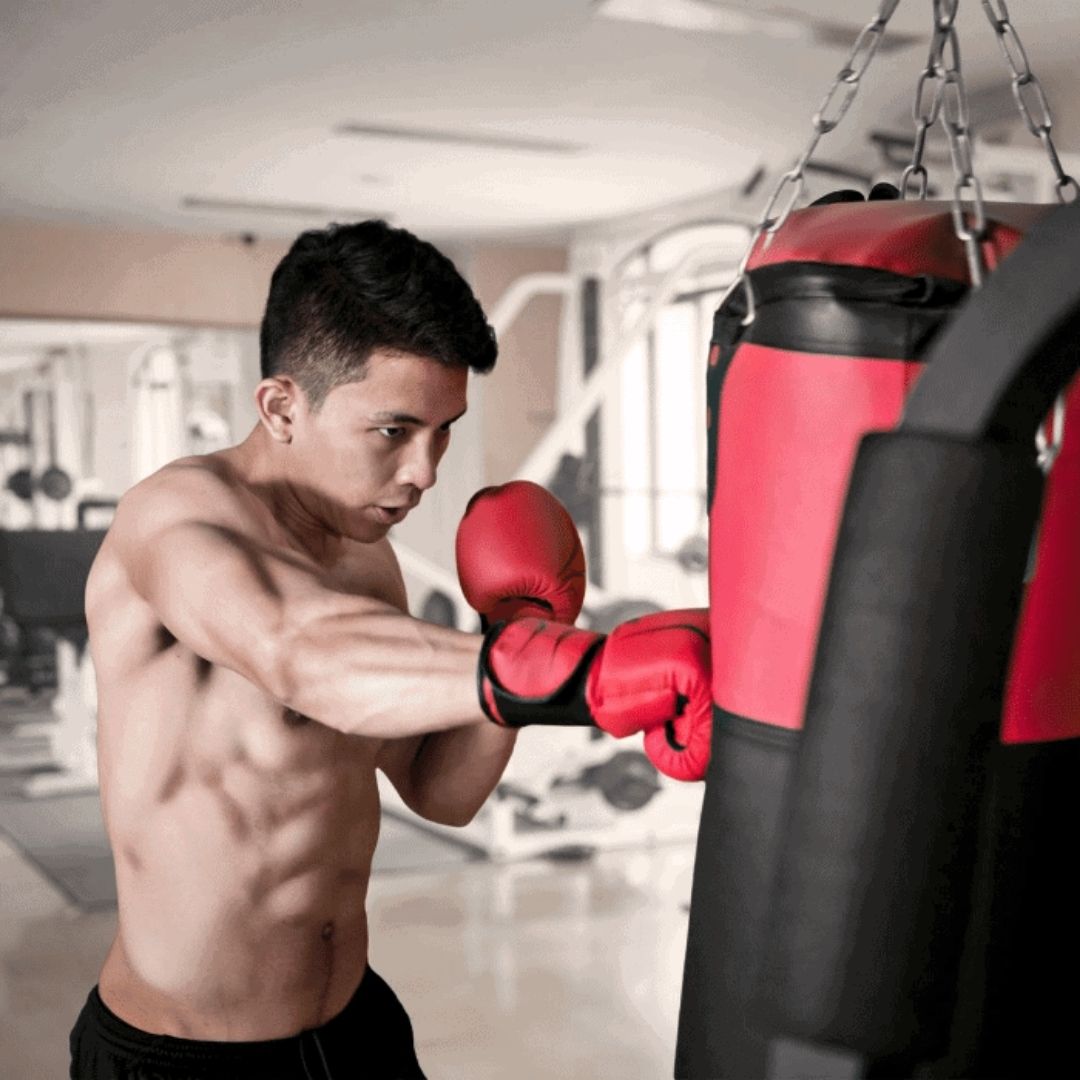 fit man man punching hanging bag